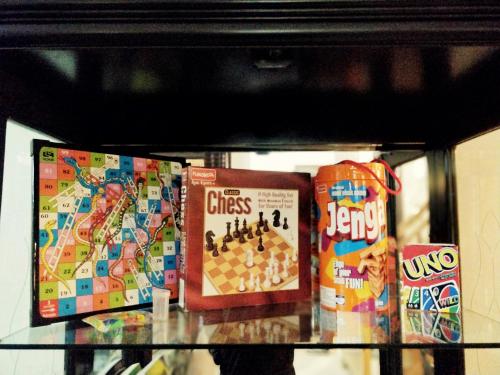 a glass shelf with games and snacks on it at Meraki - Entire 3BHK Villa With Himalayan Views in Rānīkhet