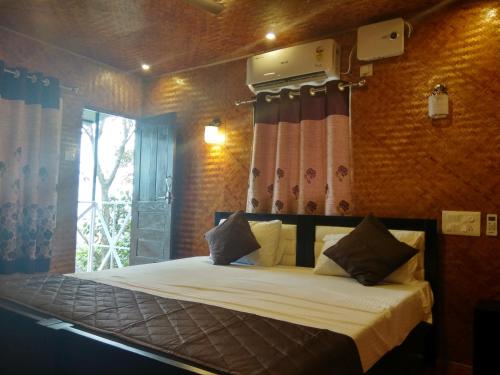 a bedroom with a bed in a room with a window at Mistywindvalley in Kudayattūr