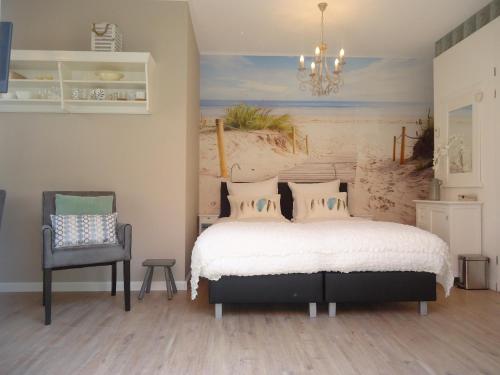 a bedroom with a bed and a chair at Bed & Breakfast Zeeduinsepoort met Sauna in Oostkapelle
