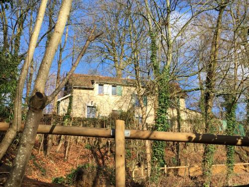 a house in the woods behind a wooden fence at Appart'Village Jouy La longère in Jouy-en-Josas