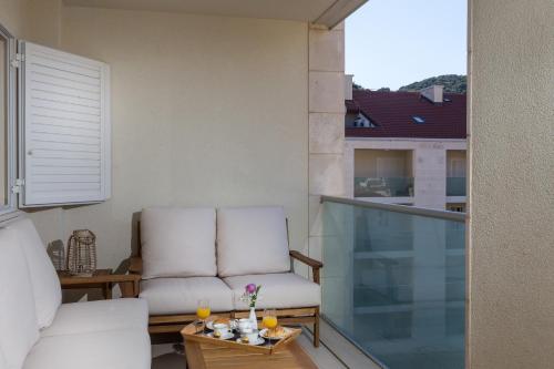 een woonkamer met een bank en een stoel op een balkon bij Apartments Nav in Dubrovnik