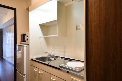 a kitchen with a sink and a refrigerator at The BREAKFAST HOTEL PORTO Ishigakijima in Ishigaki Island