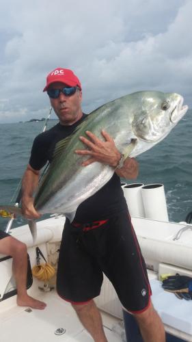 a man holding a fish in his hand on a boat at Beached Bungalow Overlooking the Pacific Ocean in Boca Chica