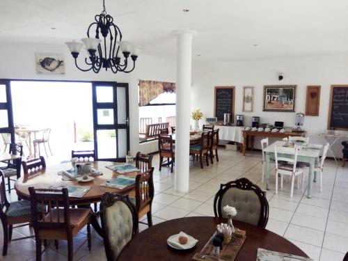 Kairos Cottage B&B في لودريتز: غرفة طعام مع طاولات وكراسي وغرفة مع غرفة طعام