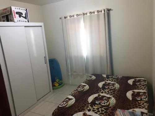 a bedroom with a bed and a closet with a curtain at Casa com piscina, wifi e churrasqueira em unamar. in Tamoios