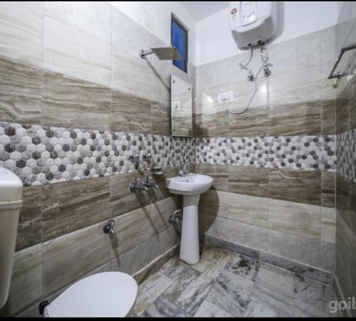 a bathroom with a sink and a toilet and a mirror at Hotel Today, Katra in Katra