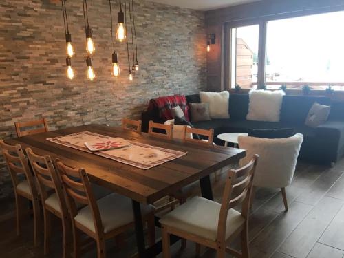 Verbier Medran + Private Sauna في فيربير: غرفة طعام مع طاولة وكراسي وأريكة