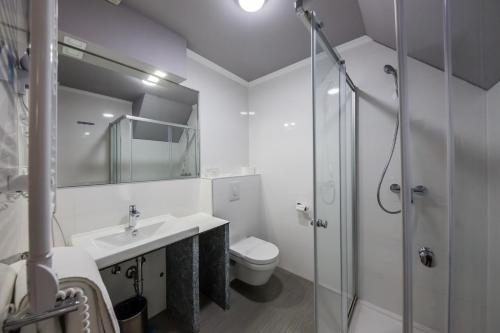 a bathroom with a toilet and a sink and a shower at Hotel Sveti Kriz in Trogir