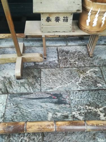 a stone floor with wooden sticks and a table at NEBULA K in Kumagaya