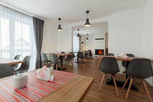 a dining room with tables and chairs and a fireplace at Apartamenty "Między Szczytami" in Tylicz