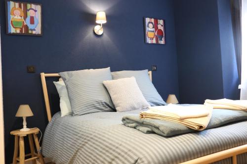 - une chambre bleue avec un lit aux murs bleus dans l'établissement La Maison des Charpentiers, à Zimmerbach
