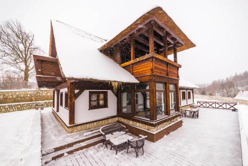 a building with snow on the roof of it at Ranczo Pod Strzechą in Stara Kamienica