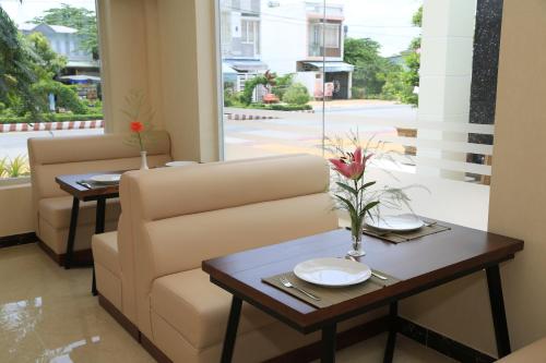 a living room with a couch and tables and a window at Van Kim Long in Ấp Ðông Quì