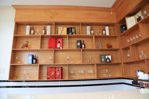 a large wooden shelf with wine glasses on it at Van Kim Long in Ấp Ðông Quì