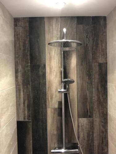 La salle de bains est pourvue d'une douche et de murs en bois. dans l'établissement Hotel Les Hauts de Porto-Vecchio, à Porto-Vecchio