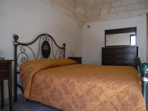 una camera con letto, cassettiera e specchio di Casa Nina by RENTHOUSESALENTO - a 50 m dal mare a San Foca