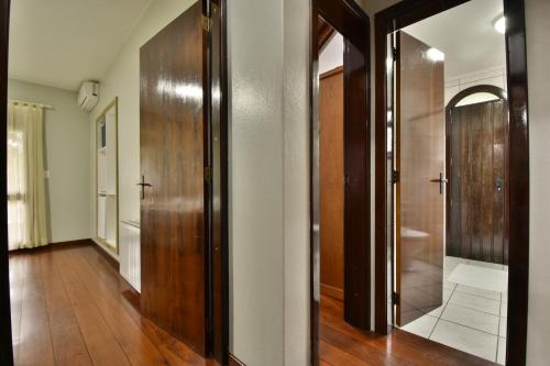 a hallway with a wooden door and a mirror at Hotel Pequeno Bosque in Gramado