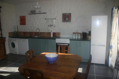 a kitchen with a wooden table with a blue bowl on it at L'ancienne cave in Prinçay