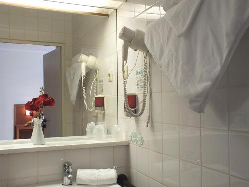 a bathroom with a sink and a mirror at Parkhotel Olsberg in Olsberg