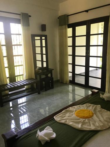 a room with a bed and a room with windows at Iwamisou in Sigiriya