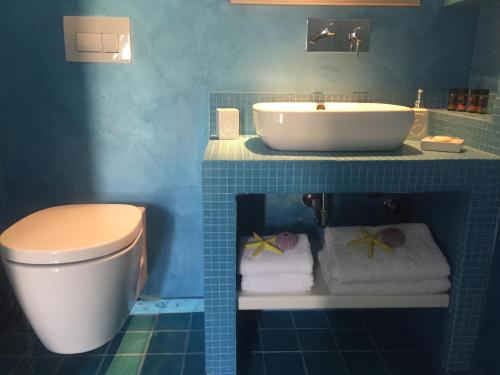 a blue bathroom with a sink and a toilet at Gorgona in Mylopotas