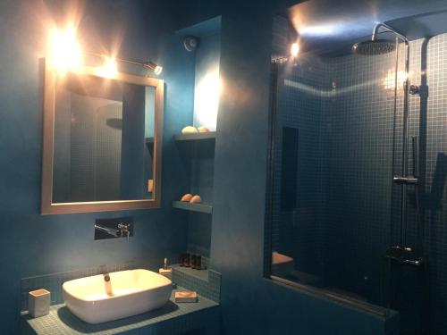 a bathroom with a sink and a shower and a mirror at Gorgona in Mylopotas