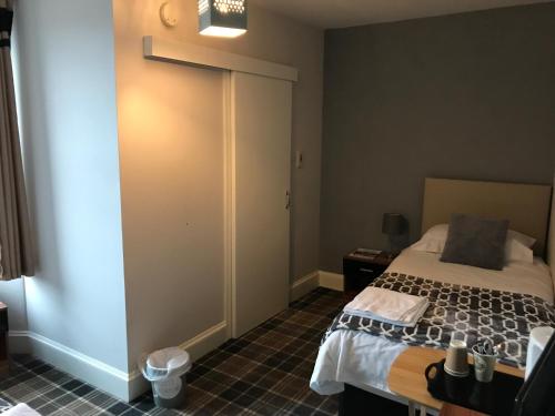 a bedroom with a bed and a sliding door at Whisky Capital Inn in Dufftown