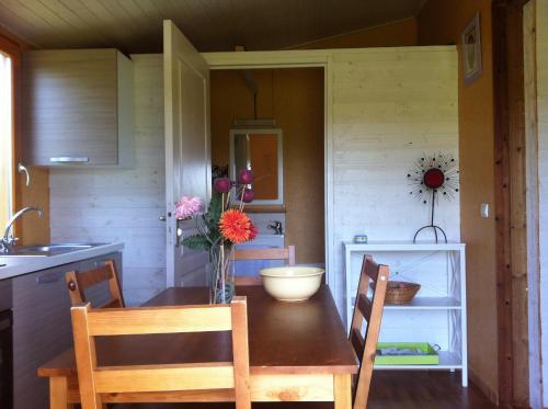 une cuisine avec une table et un vase de fleurs. dans l'établissement Domaine De Silvabelle, à Mars-sur-Allier