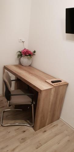 a wooden desk with a vase of flowers on it at Ubytování Cukrovar in Lovosice