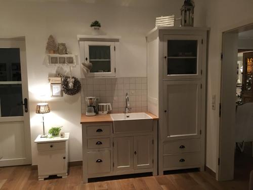 a kitchen with a sink and a cupboard at White Cottage Garden in Cloppenburg