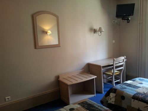a room with a desk and a bed and a mirror at Hotel Azur in Lyon