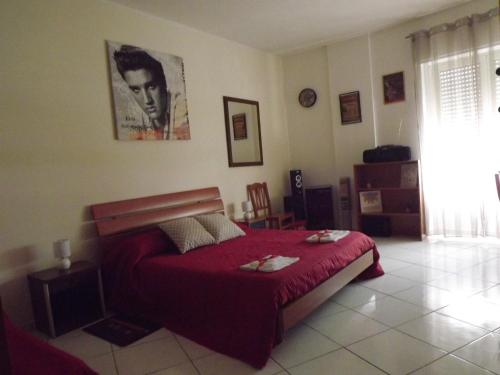 a bedroom with a bed with a red bedspread at Sa Sindria in Cagliari