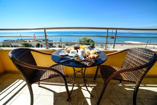 una mesa con comida en el balcón con vistas al océano en Hotel Panoramico en Scauri