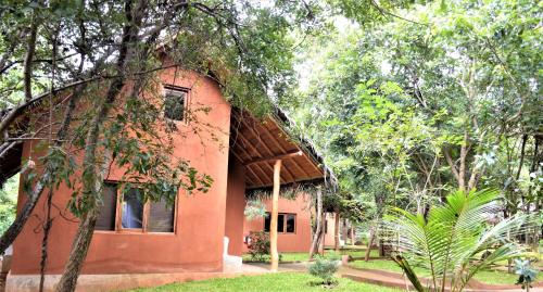 a small orange building in the middle of trees at Kuwera Eco Lodge in Sigiriya