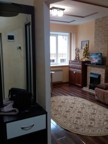 エッセントゥキにあるOrdzhonikidze Street Apartmentのリビングルーム(大きな鏡、暖炉付)
