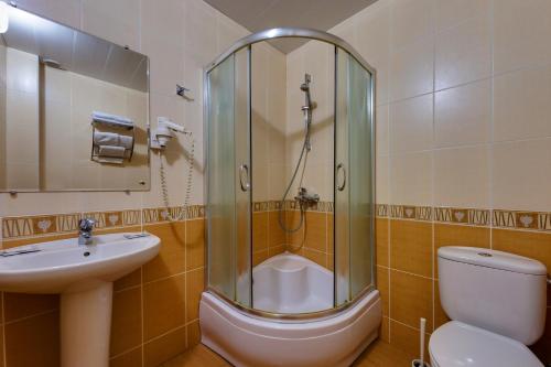 a bathroom with a toilet, sink and shower stall at Vizit Hotel in Krasnodar