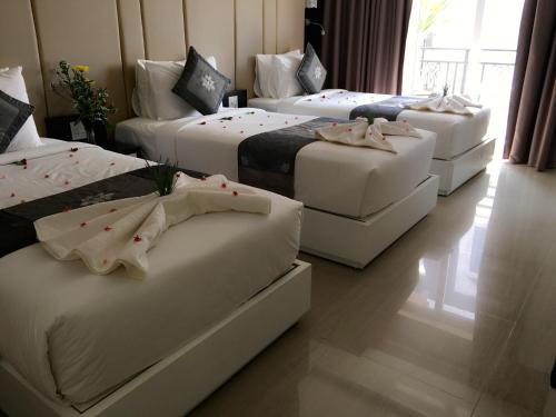 a group of four beds in a room at Muine Sports Hotel in Mui Ne