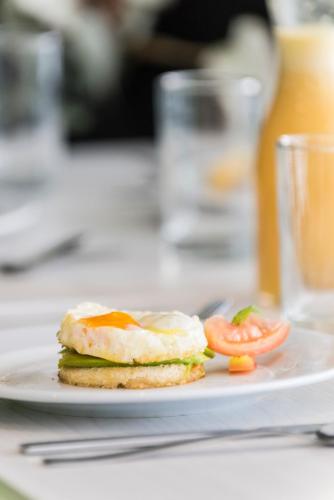a plate with a breakfast sandwich on a table at Foresta Hotel in Medellín