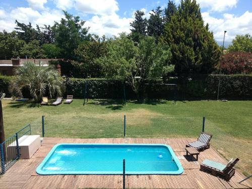 a swimming pool in a yard with two chairs at Ayres de Vistalba in Ciudad Lujan de Cuyo
