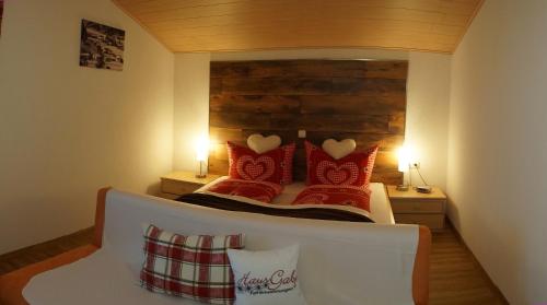 a bedroom with a bed with red pillows at Haus Gaby in Holzgau