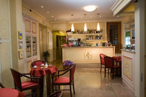 a restaurant with a table and chairs and a bar at Hotel Leon D'Oro in Orta San Giulio