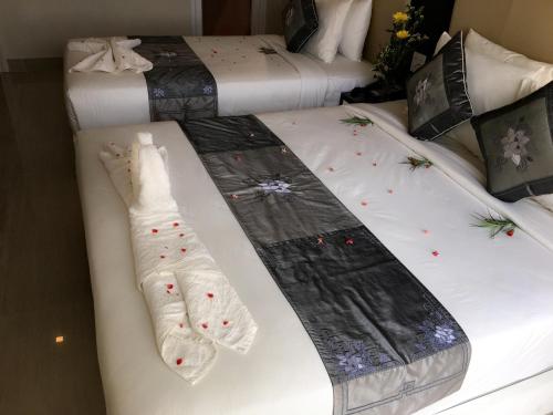 two beds with christmas socks and gloves on them at Muine Sports Hotel in Mui Ne
