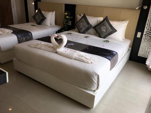 two beds with swans on them in a room at Muine Sports Hotel in Mui Ne