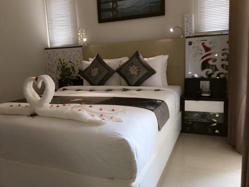 a bedroom with a white bed with a swan on it at Muine Sports Hotel in Mui Ne