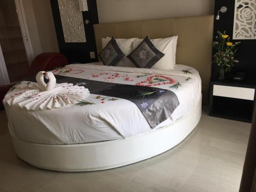 a large bed with a white bed frame in a room at Muine Sports Hotel in Mui Ne