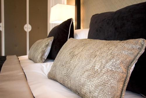 a couch with three pillows on top of it at The Inn On The Green in Cookham Dean