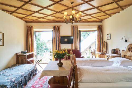 Un dormitorio con 2 camas y una mesa con flores. en Hotel Post Mauterndorf OG, en Mauterndorf