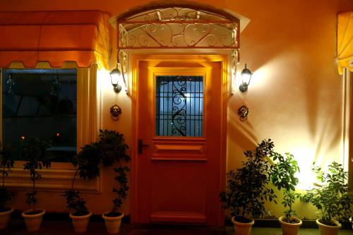 a red door with a window and potted plants at Stay Banaras - A Boutique Hotel in Varanasi