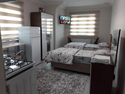 a bedroom with a bed and a kitchen with a stove at Moonlight pansiyon in Erzincan