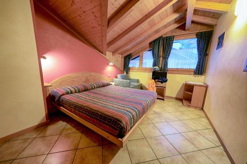 ヴァルディデントロにあるRosengarden Alpine Residenceのベッドルーム1室(大型ベッド1台付)